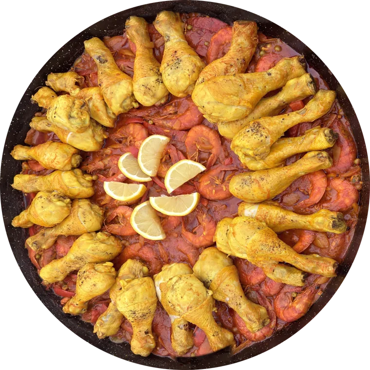 Paëlla du chef vue du dessus, garnie de poulet, de gambas et de citrons