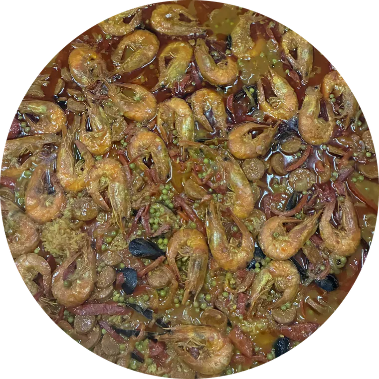 Paëlla vue du dessus, garnie de gambas, de moules et de petits pois